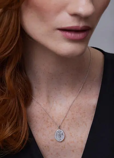 Close up of red haired model wearing Sterling Silver Mother of Pearl Celtic Cross Medallion Pendant with White Crystals 
